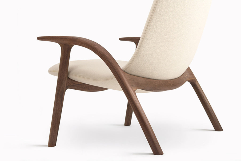 Rückansicht des Loungesessels von GoEs mit geschwungenem Holzrahmen und hellem Stoffbezug