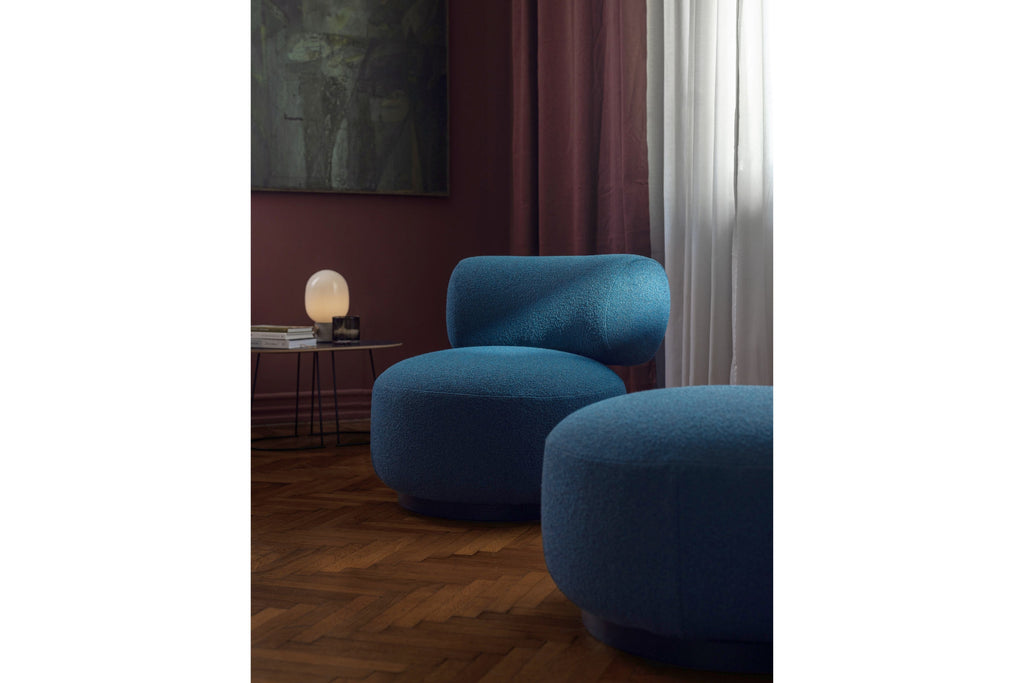 Sessel und Pouf in Blau in modernem Wohnzimmer mit Lampe
