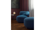 Sessel und Pouf in Blau in modernem Wohnzimmer mit Lampe