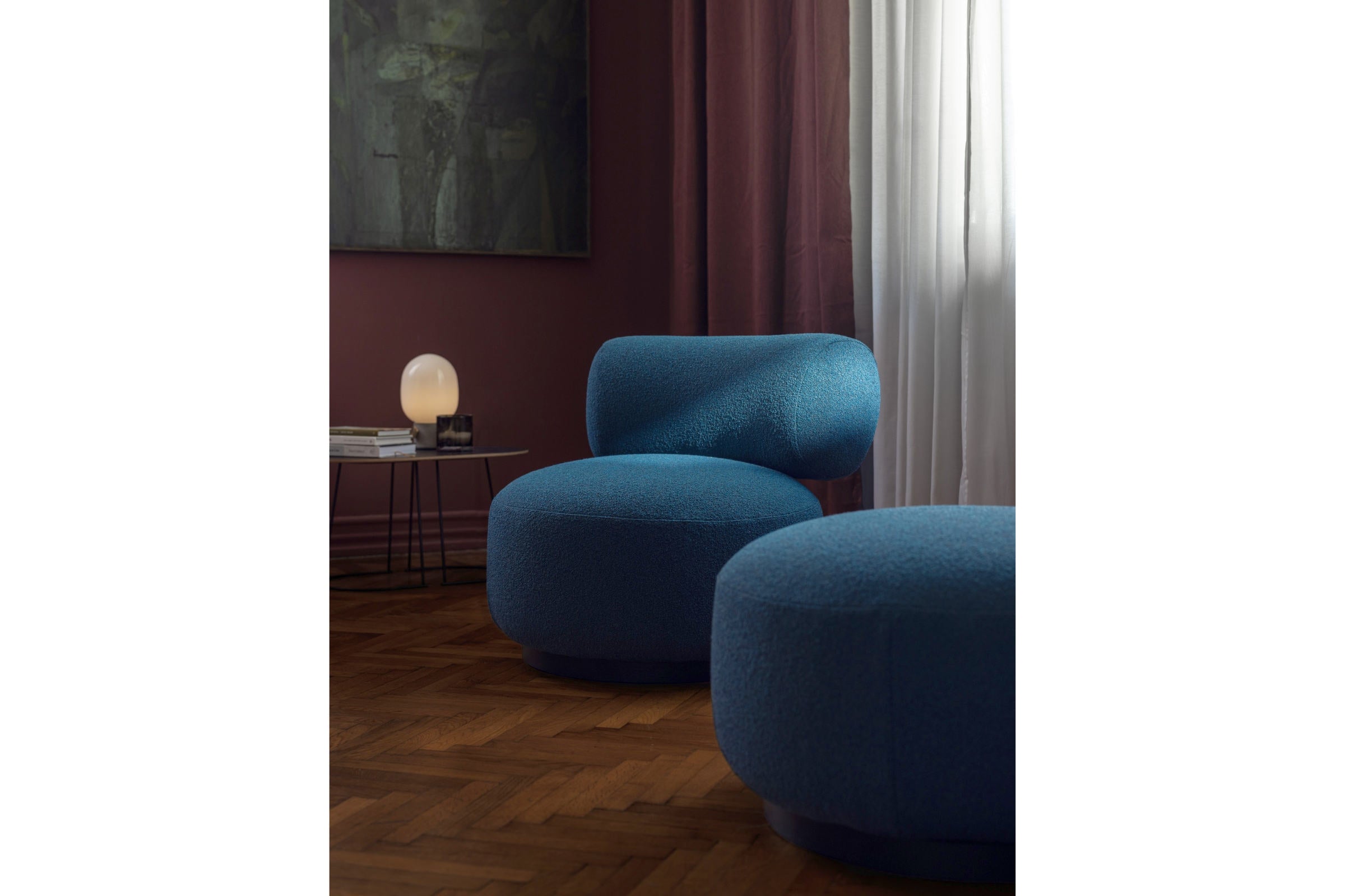 Sessel und Pouf in Blau in modernem Wohnzimmer mit Lampe