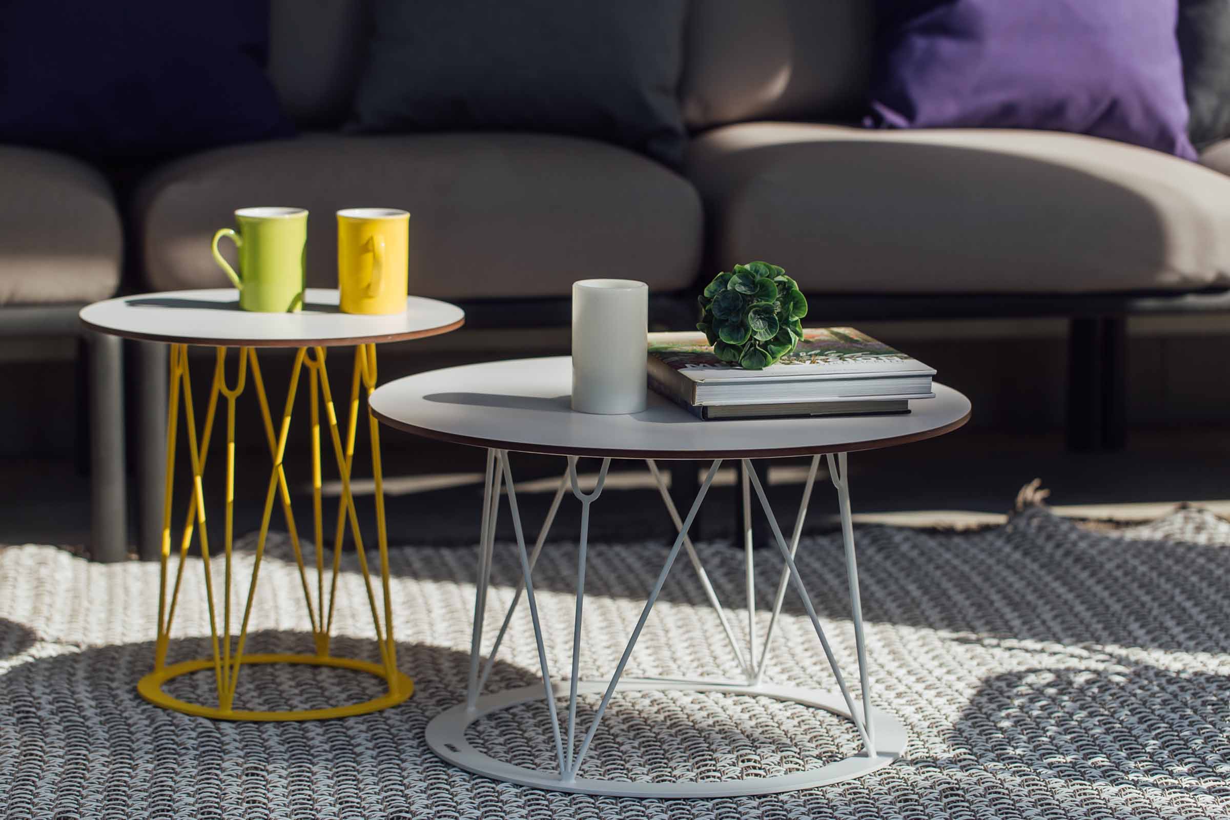 Zwei Gartenclubtische von GARDA, einer in Gelb, einer in Weiß, mit Tassen und Kerzen dekoriert