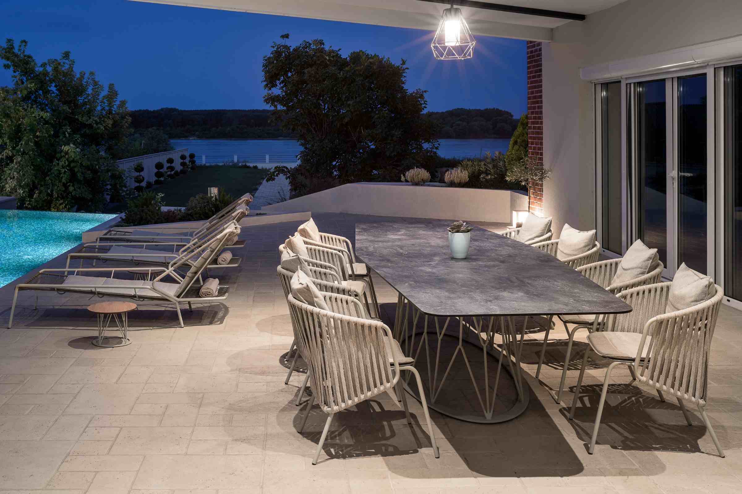 Gartenstühle in hellem Beige auf einer eleganten Poolterrasse