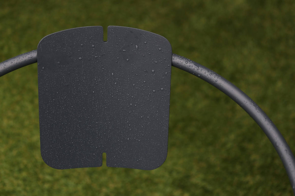 Detailaufnahme der Rückenlehne des Gartenstuhls mit Wassertropfen