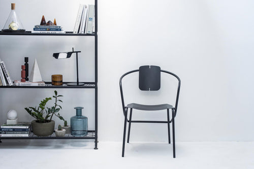 ATAMAN Designer Minimalisticher Gartenstuhl neben einem Regal mit Deko-Elementen