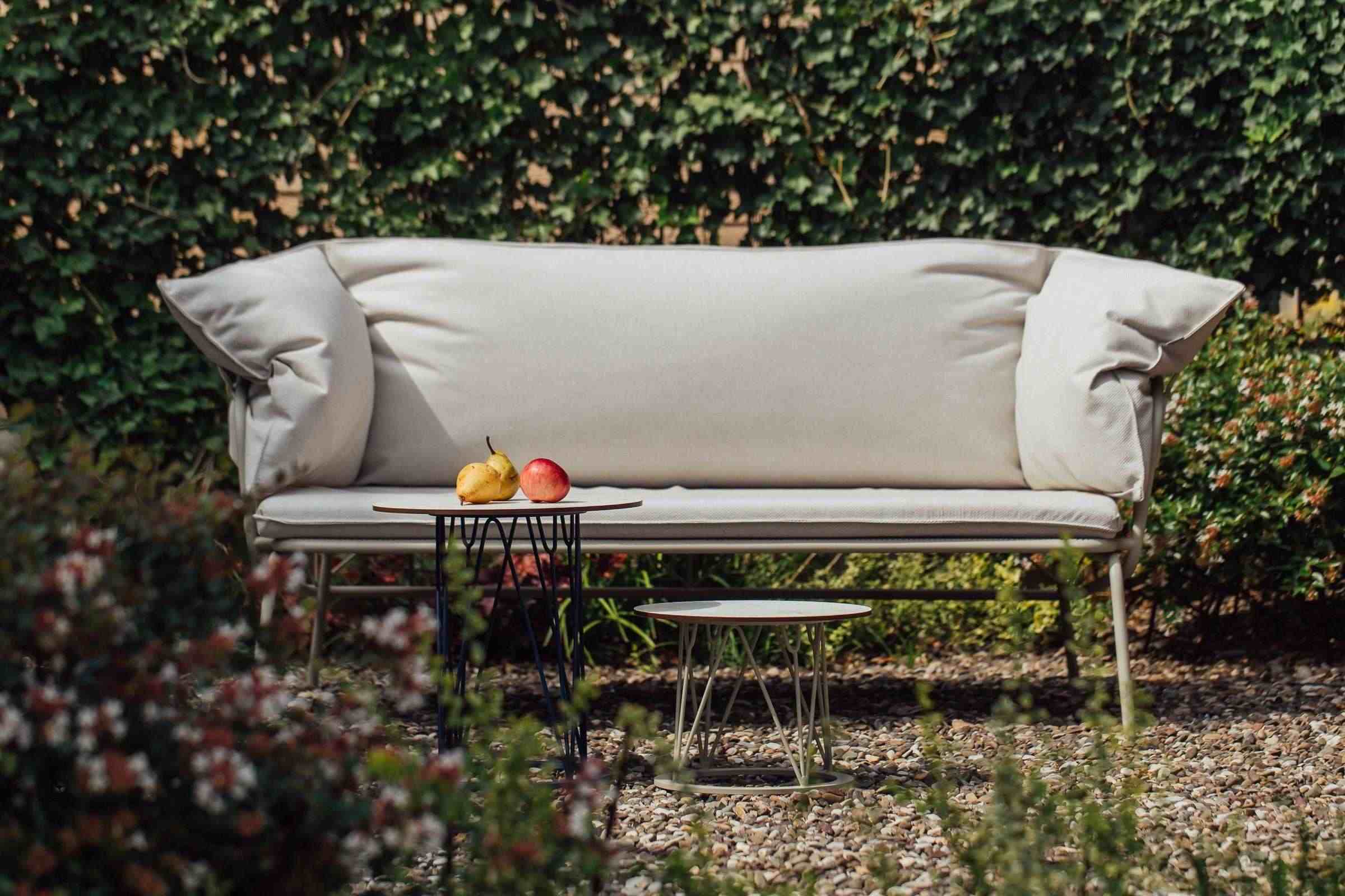 ATAMAN Designer Gartensofa in stilvoller Outdoor-Umgebung, mit grünen Pflanzen und Obst auf dem Tisch