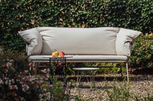 ATAMAN Designer Gartensofa in stilvoller Outdoor-Umgebung, mit grünen Pflanzen und Obst auf dem Tisch