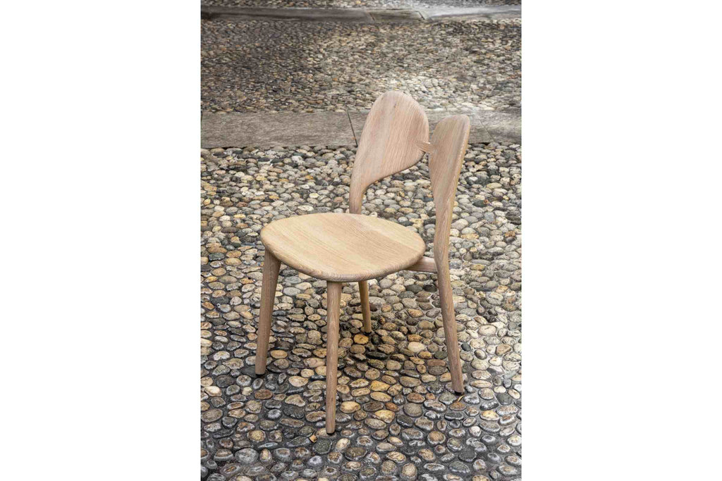 LEPIDA Designer Stuhl von Woak auf einem Kieselsteinboden platziert