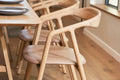 Detailansicht des BLED Designer Stuhls von Woak mit geschwungenem Holzrahmen in hellem Interieur
