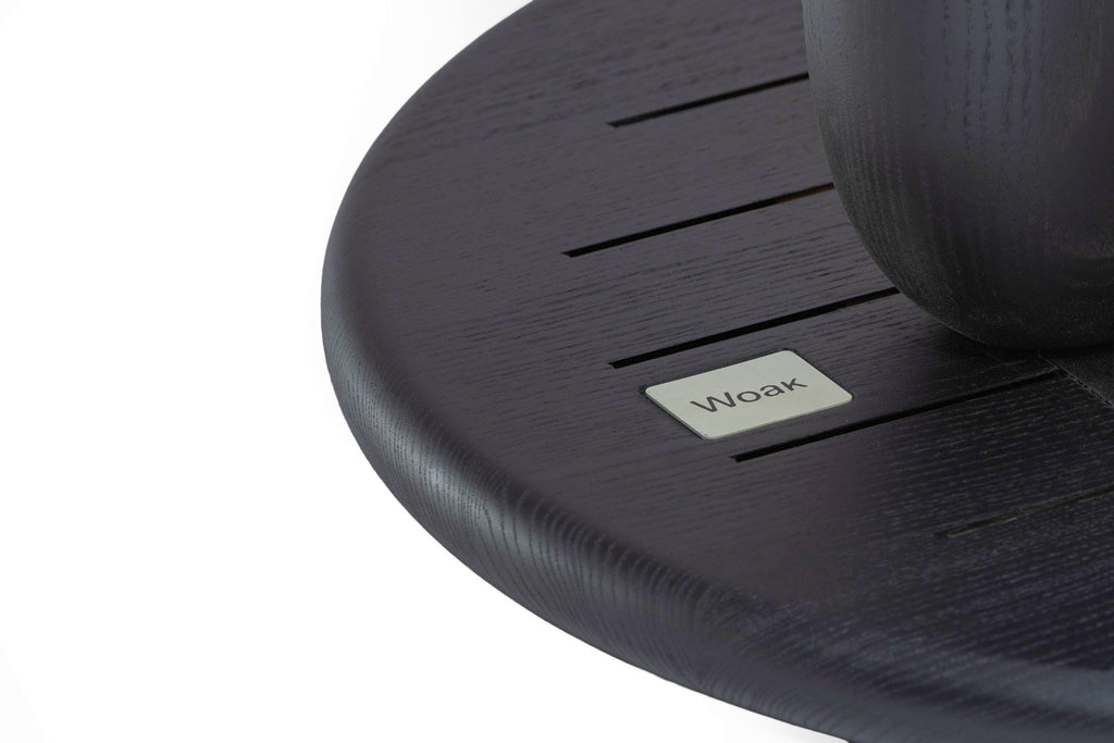 Nahaufnahme Tischplatte mit Woak-Logo auf dem Beistelltisch