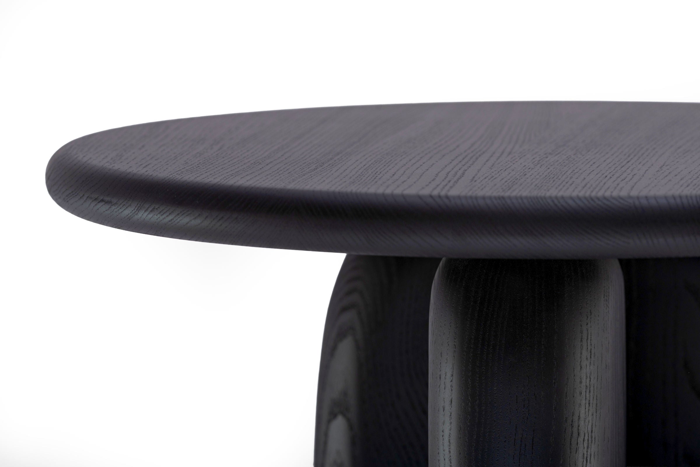 Nahaufnahme der abgerundeten Tischkante mit sichtbarer Holzmaserung