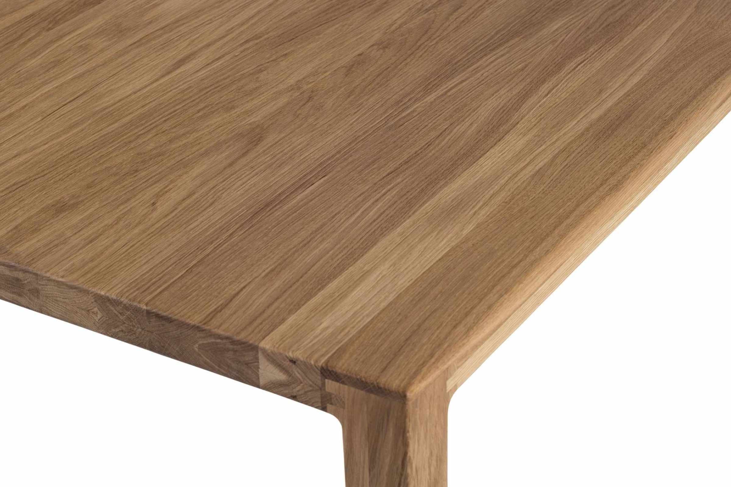 Nahaufnahme der Tischplatte des COLIN Massivholz Esstisches, die die feine Holzmaserung und die präzise Verarbeitung betont