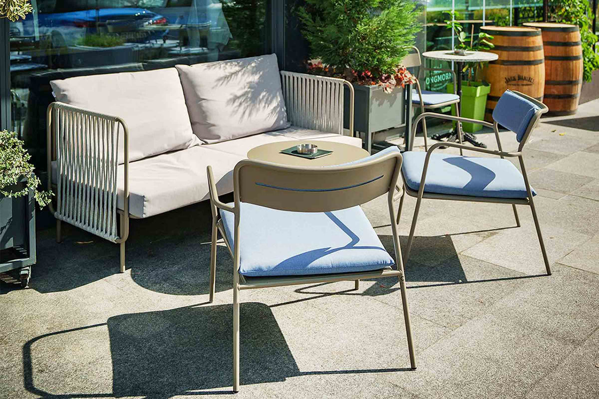 Im Außenbereich einer Terrasse mit Tisch und Sesseln