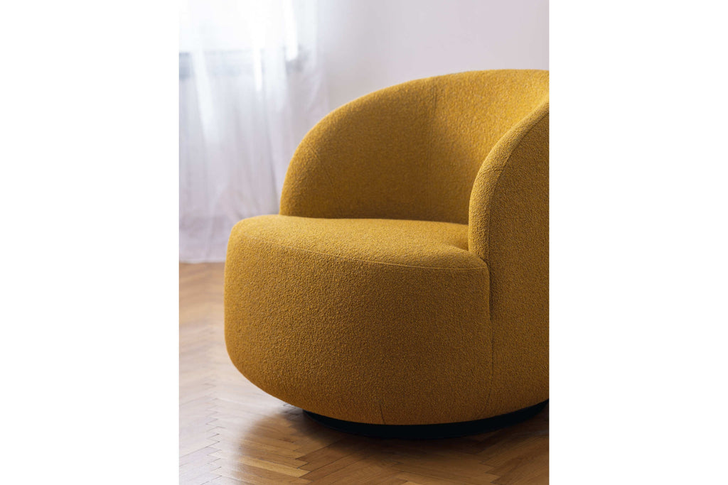 Sessel in goldenem Stoff auf Parkettboden