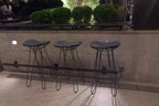 Drei Barhocker bei Nacht an einer Bar im Freien