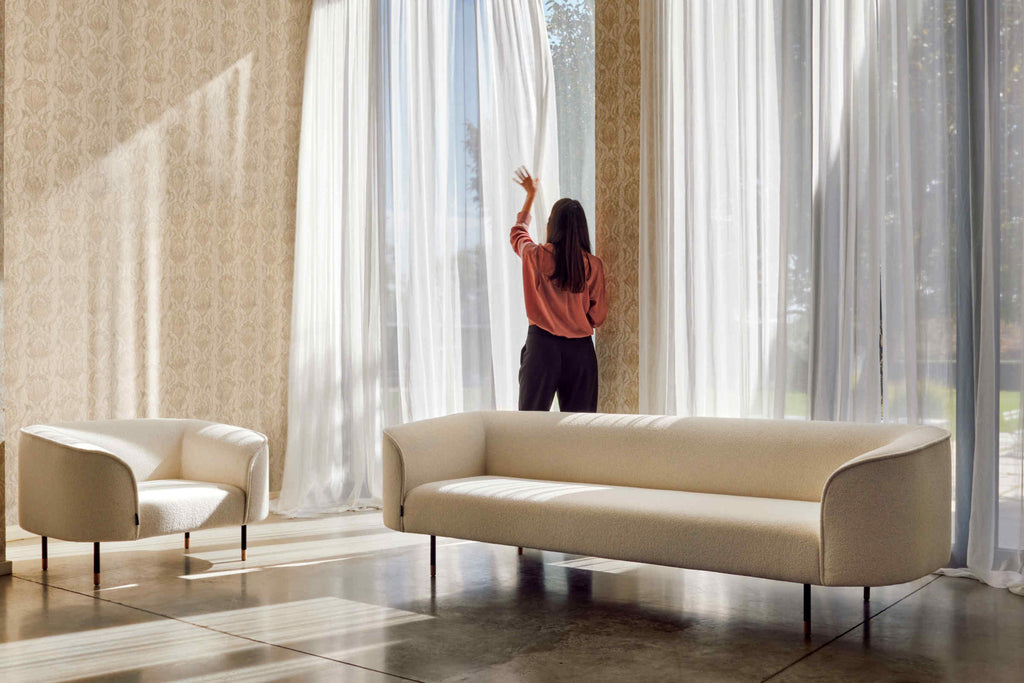 Sofa mit passendem Sessel vor großer Fensterfront