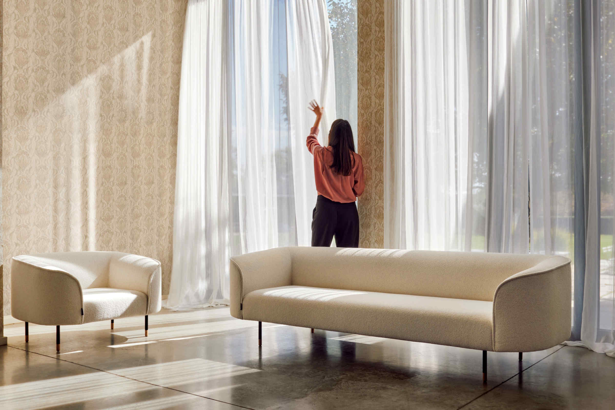 Sofa mit passendem Sessel vor großer Fensterfront