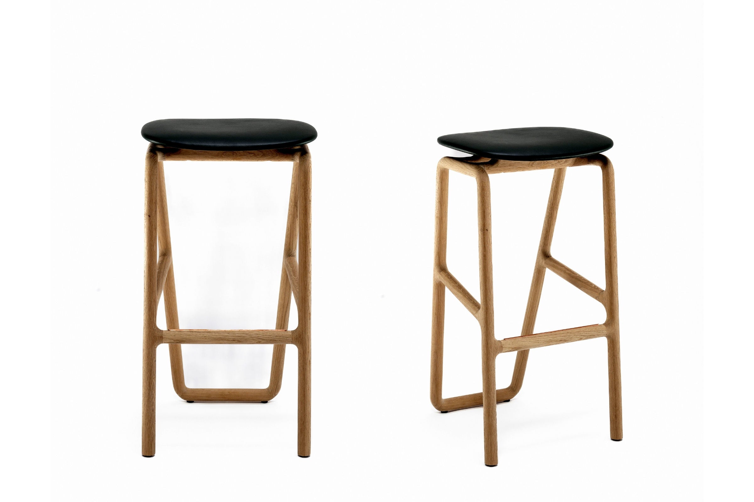 Zwei Designerhocker nebeneinander in Schräg- und Vorderansicht
