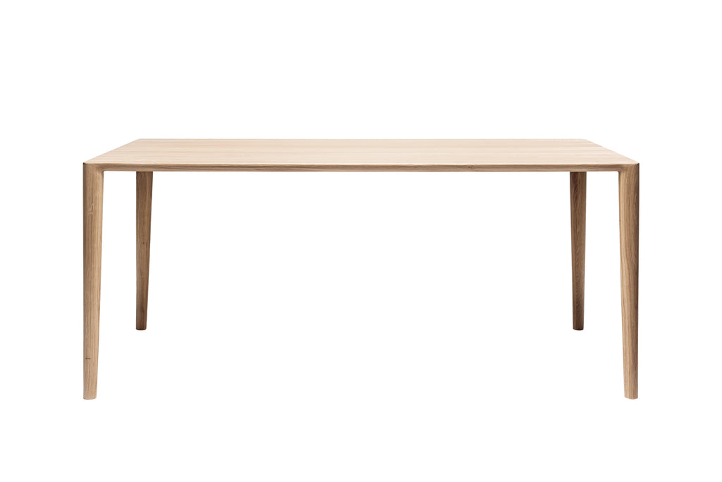 Frontalansicht des Esstisches mit klaren, schlanken Linien und einer Tischplatte aus Eichenholz