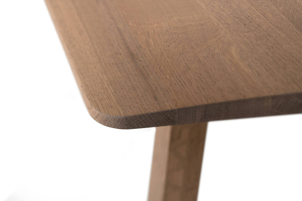 Eine Nahaufnahme des NERVOSA Esstisches mit abgerundeten Ecken und Tischbeinen