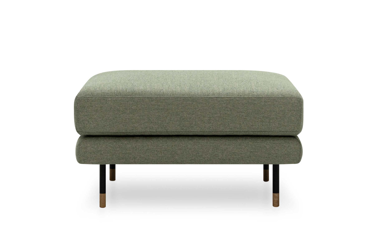 Pouf in grünem Stoff mit filigranen Metallfüßen und Holzdetails