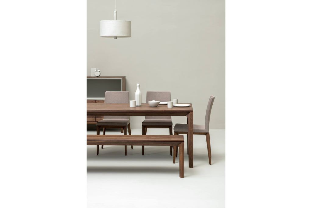 Blick auf den Esstisch und passende Sitzbank aus Nussbaumholz in einem geräumigen Esszimmer