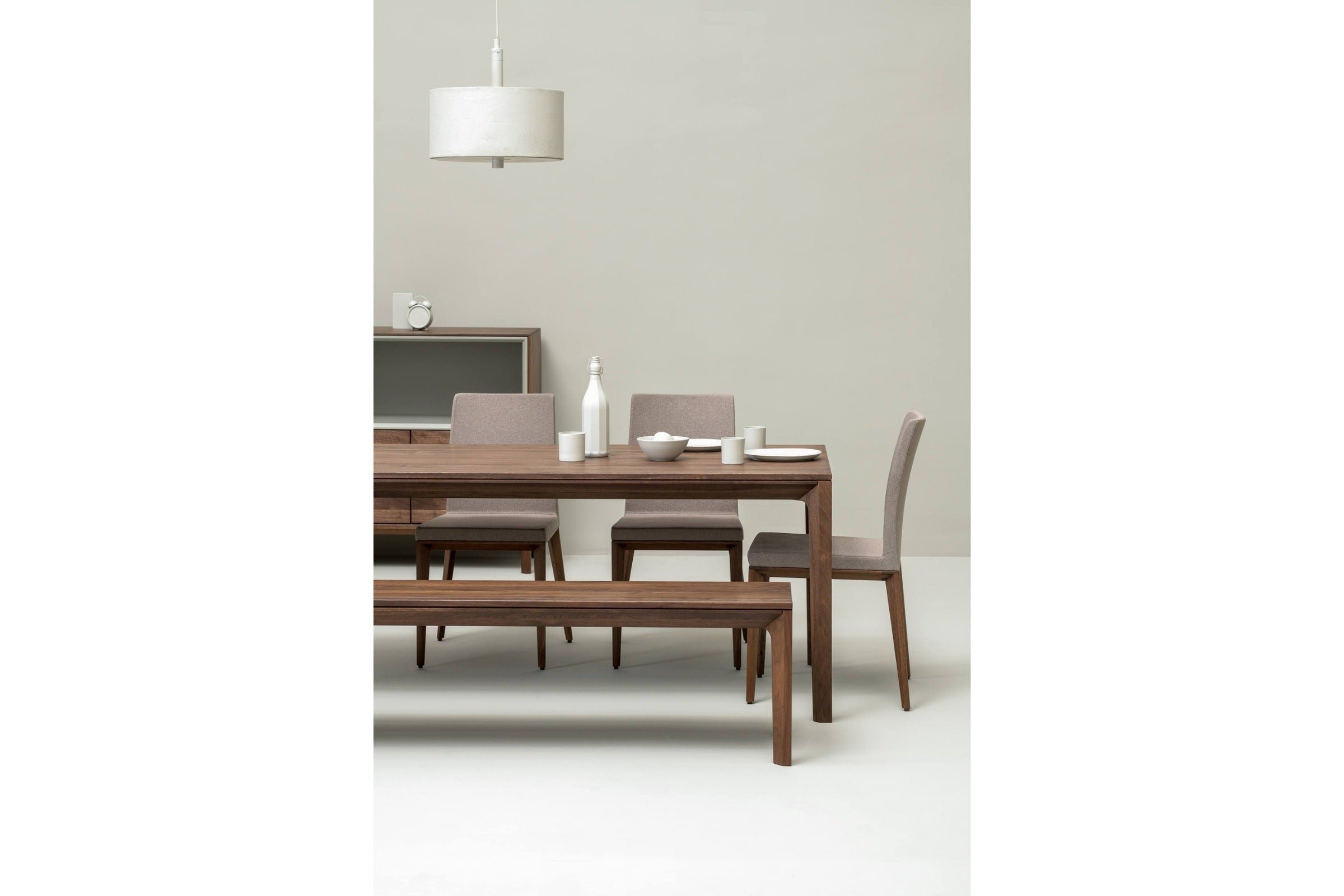 Blick auf den Esstisch und passende Sitzbank aus Nussbaumholz in einem geräumigen Esszimmer