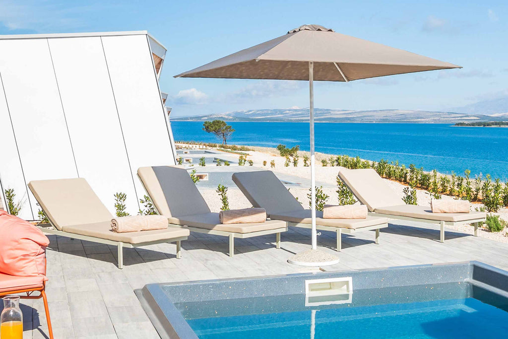 Moderne TOK Designer Sonnenliegen von EXTRAFORM auf einer Terrasse am Pool mit Meerblick