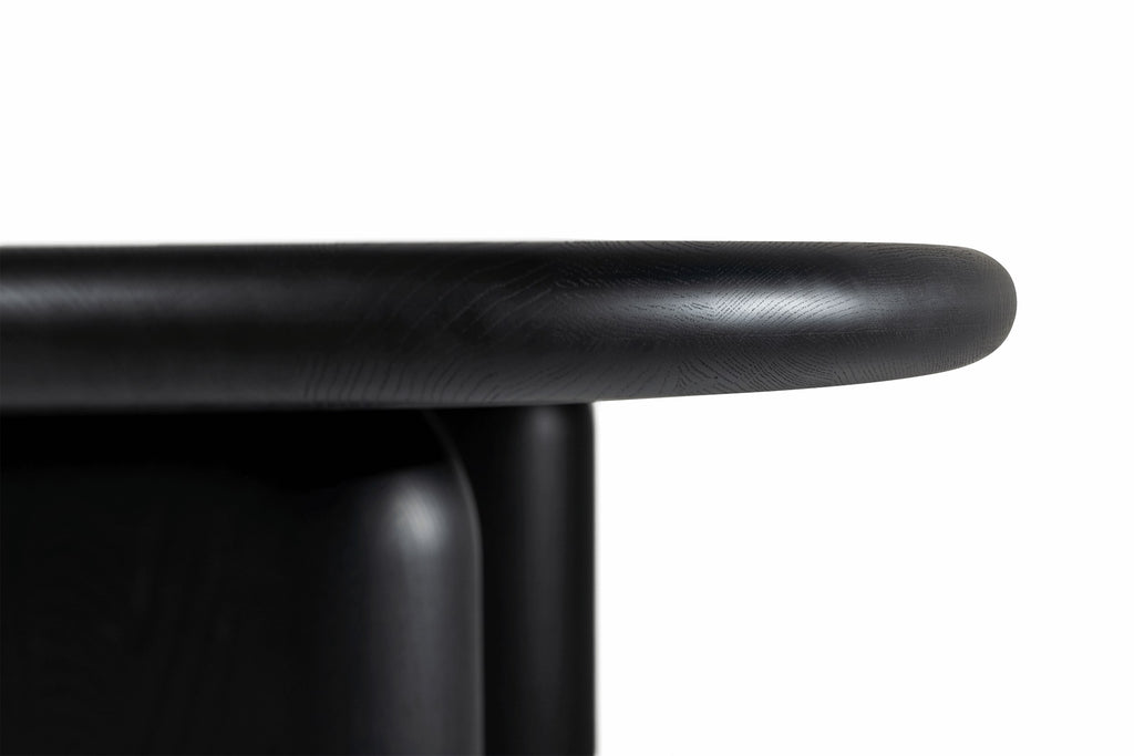 Detailansicht der abgerundeten Kante in Schwarz, die die Holzmaserung hervorhebt